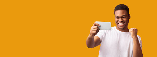 istock Happy black man using phone celebrating success 1201192400