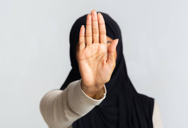 istock Black muslim woman in headscarf making stop gesture with open palm 1201192598