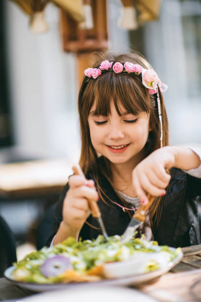 dziewczynka jedząca sałatkę warzywną - children only healthy lifestyle vertical close up zdjęcia i obrazy z banku zdjęć