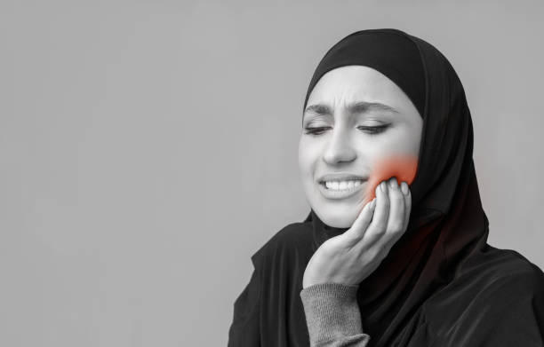 istock Woman suffering from strong tooth pain, having hypersensitivity, touching her cheek 1201193514