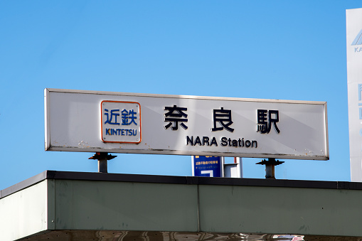 Nara, Japan- 27 Nov, 2019: Nara station signboard with Japanese kanji and English Nara word under the blue sky.