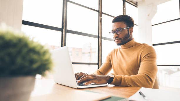 istock Afro man working on laptop in modern office 1201194984