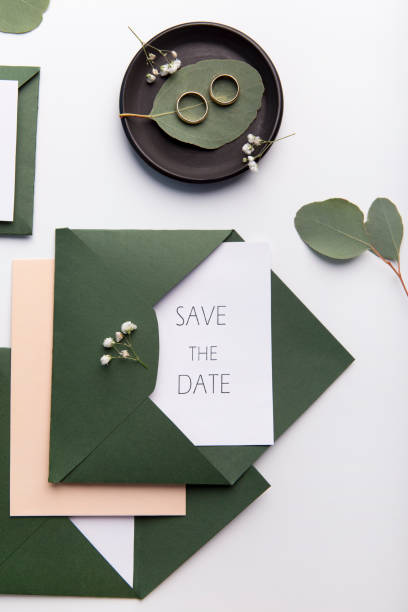 istock Stylish wedding invitations and golden rings on white 1201195392