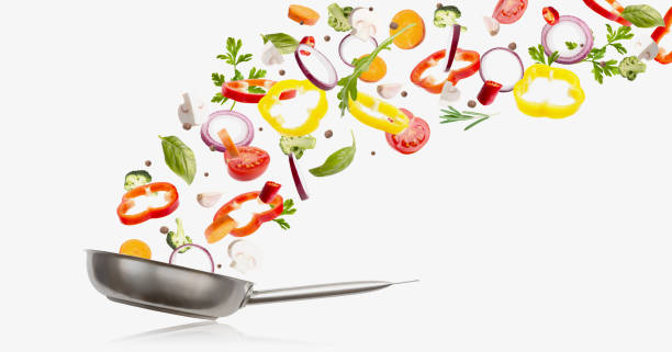 istock Fresh vegetables flying into a pan, isolated on white 1201195684