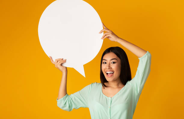 istock Great idea. Asian girl holding empty speech bubble 1201196110