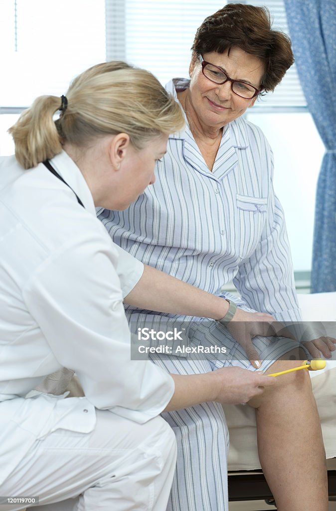 in hospital Physician checking reflexes of an senior woman in hospital Adult Stock Photo