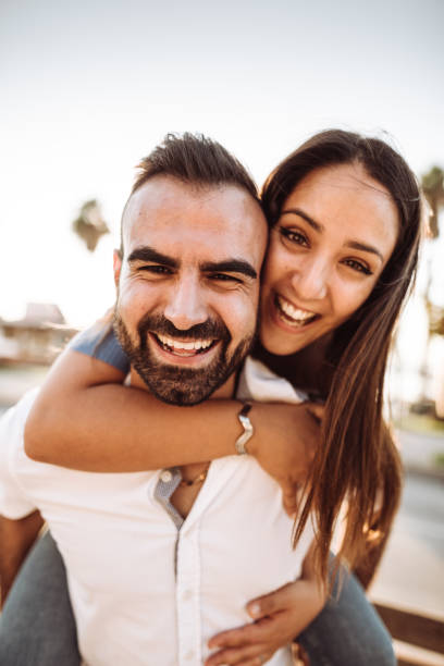 istock piggybacking couple at dusk on vacation 1201198095