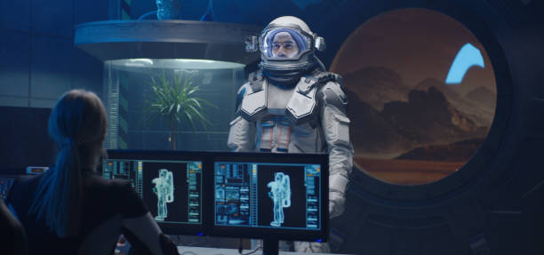 istock Female astronaut helping man with spacesuit 1201198689