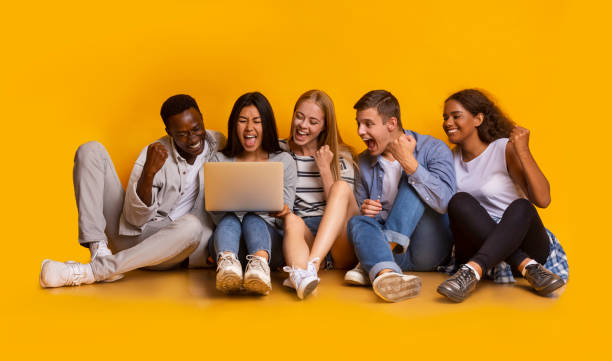 istock Group of students checking exam results online over yellow background 1201198749