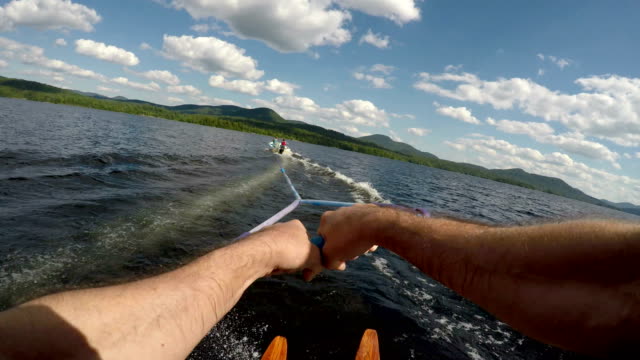 POV of a healthy fit man water skiing on a pristine mountain lake