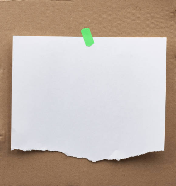 istock blank paper ad with torn edges attached with a green velcro on a brown cardboard surface 1201200444