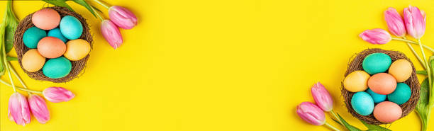 istock Stylish background with colorful easter eggs isolated on yellow background with pink tulip flowers. Flat lay, top view, mockup, overhead, template 1201202291
