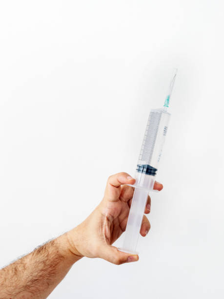 istock man is holding a big syringe 1201203333