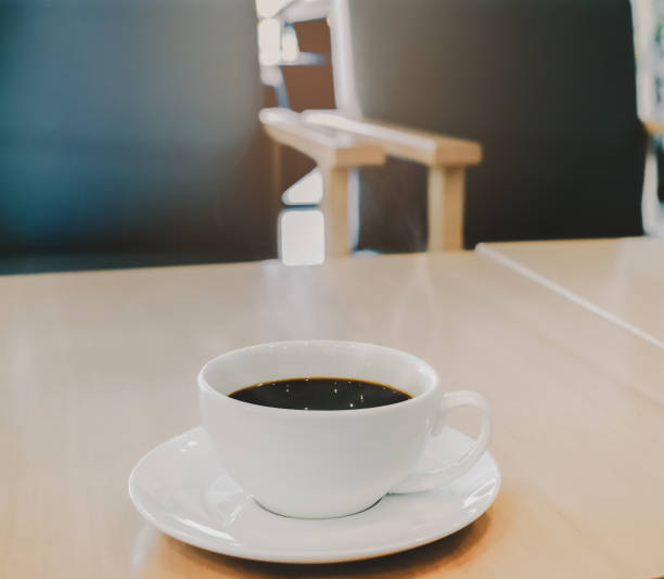 gorąca kawa filiżanka kawy na drewnianym stole w godzinach porannych. - starbucks coffee bean editorial zdjęcia i obrazy z banku zdjęć