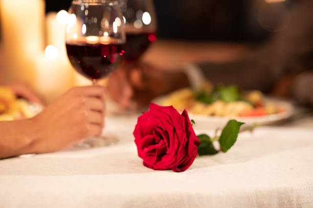 istock Unrecognizable Couple Holding Two Red Wine Glasses Sitting In Restaurant 1201204645