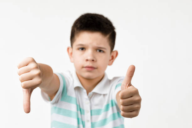 istock child boy showing the thumbs down and thumbs up gesture 1201204748