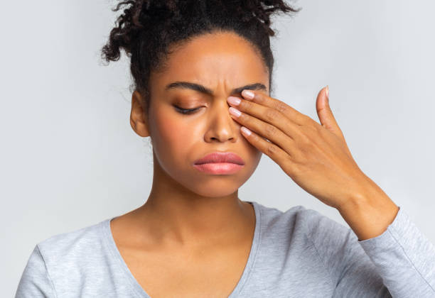 istock Sad black girl touching her eye, suffering from conjuctivitis 1201204817