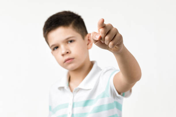 istock Cute little boy in striped t-shirt pointing camera 1201204847