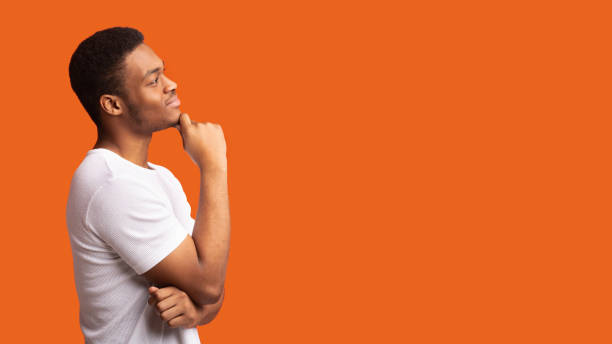 istock Pensive afro man profile portrait on orange background 1201207350