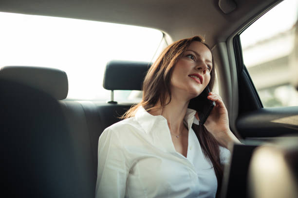 istock Beautiful business lady talking on mobile in car 1201207619