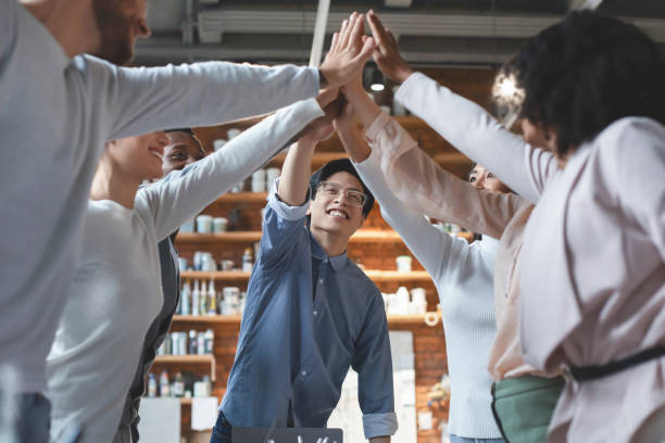 istock Multiracial young team giving high five in office 1201207901