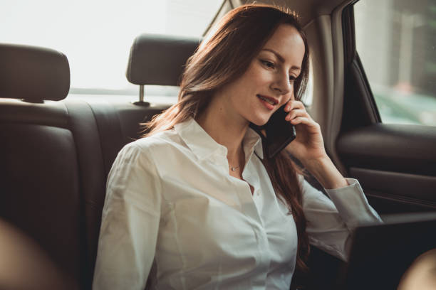 istock Beautiful business lady talking on mobile in car 1201208101