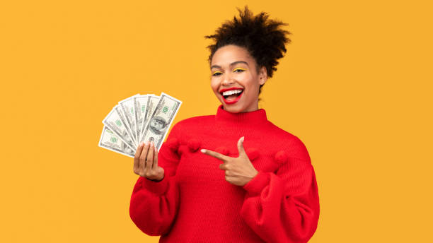 istock Happy black girl holding money at studio 1201208165