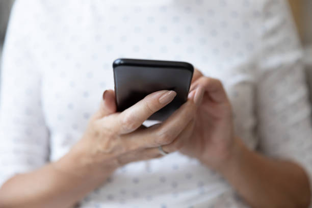 istock Close up of mature female using smartphone browsing internet 1201208509