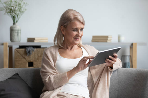 istock Elderly woman relax at home using electronic tablet 1201208574
