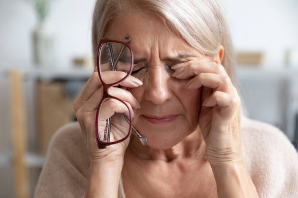 nahaufnahme von ungesunden alten frauen leiden an migräne - human eye rubbing tired glasses stock-fotos und bilder