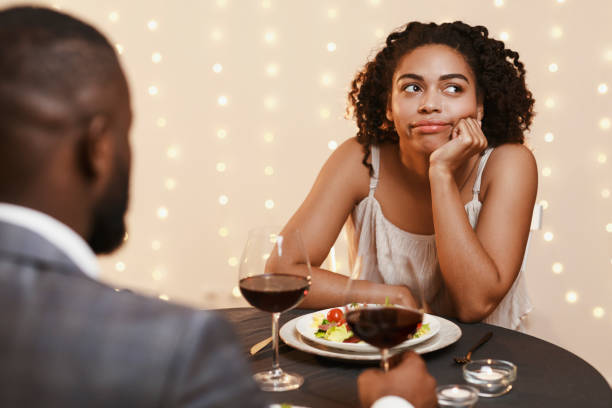 istock Bored afro woman attending first date at restaurant 1201210151