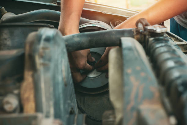 istock Young mechanic working use a wrench and fixing old car 1201210646
