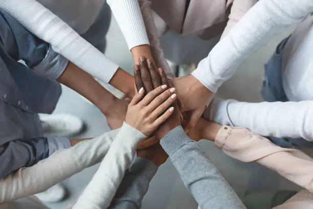 Photo of Business team putting hands together on top of each other