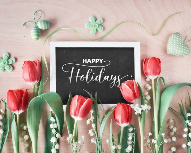 istock Spring composition with blackboard framed with springtime flowers, tulips and lily of the valley on clean wood. Text 