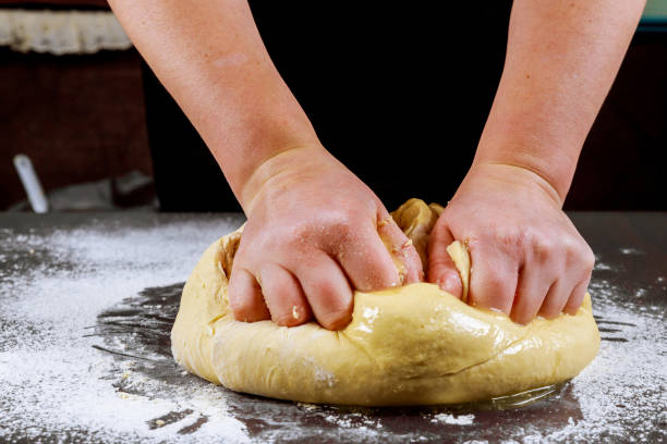 istock Woman kneading dough for making pizza. 1201217304