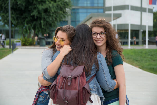 istock Female students hugging in front of a campus 1201220631