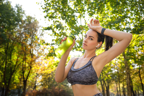 istock sporty woman drinking water 1201221444
