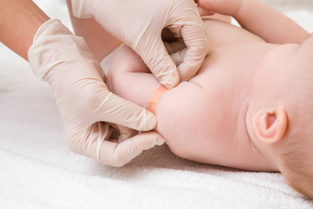 istock Doctor hands in white rubber protective gloves putting adhesive bandage on infant shoulder after injection of vaccine. Medical concept. Closeup. 1201224631