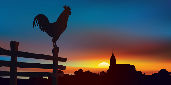Countryside landscape at daybreak with, in the foreground, a rooster perched on a barrier and on the horizon a traditional village of France.