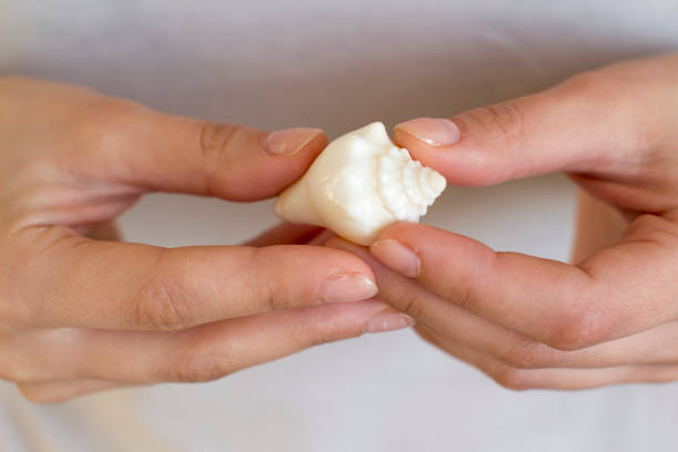 istock young woman holding a sea shell 1201230008