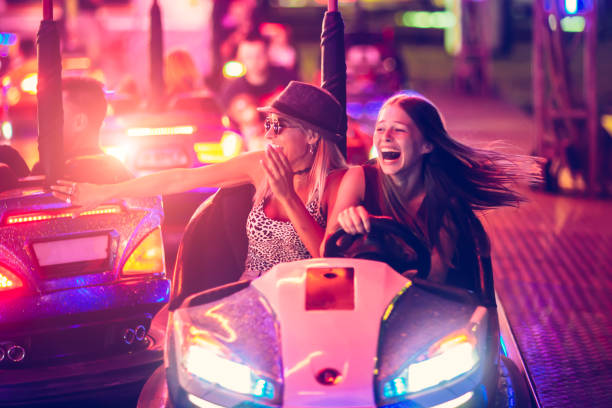 chicas divirtiéndose en coche de choque eléctrico en el parque de atracciones - park and ride fotografías e imágenes de stock