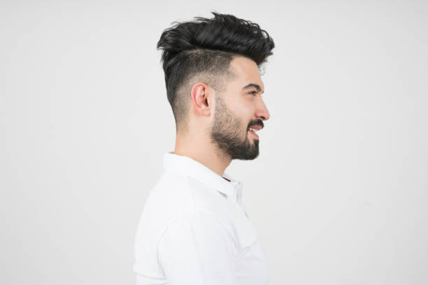side view of handsome young man in gray background stock photo