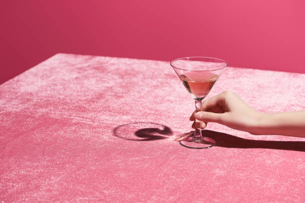 vista ritagliata di donna che tiene un bicchiere di vino rosa su stoffa di velluto isolato su un concetto rosa e femminile - pink glasses foto e immagini stock