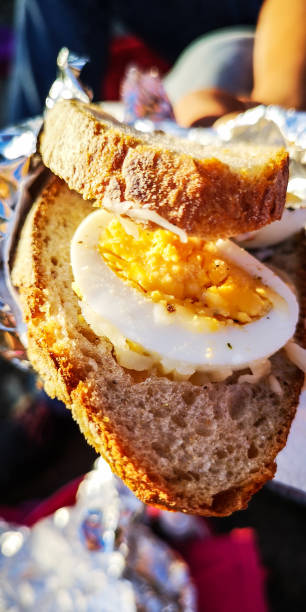 istock View on an opened sandwich with slices of a cooked egg in a hand with sunlight 1201234373