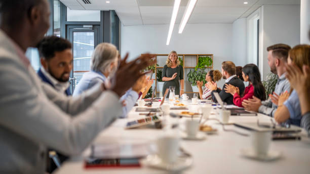 istock People applauding businesswoman at a conference table 1201239961