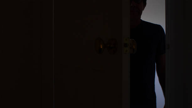 istock Silhouette of a man standing in a half open doorway. 1201240537