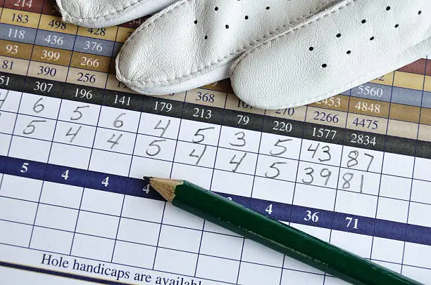 Close up of Golf Score Card with Glove and Green Pencil