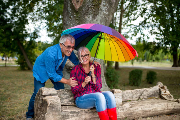 istock The old couple in the rain with umbrellas 1201246531