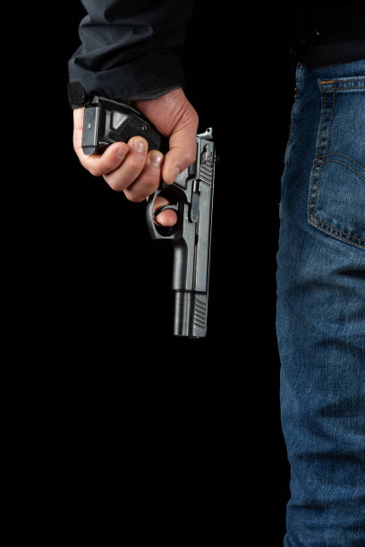 istock A man with a gun on a black background. 1201248288