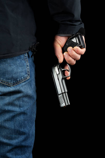 istock A man with a gun on a black background. 1201248454
